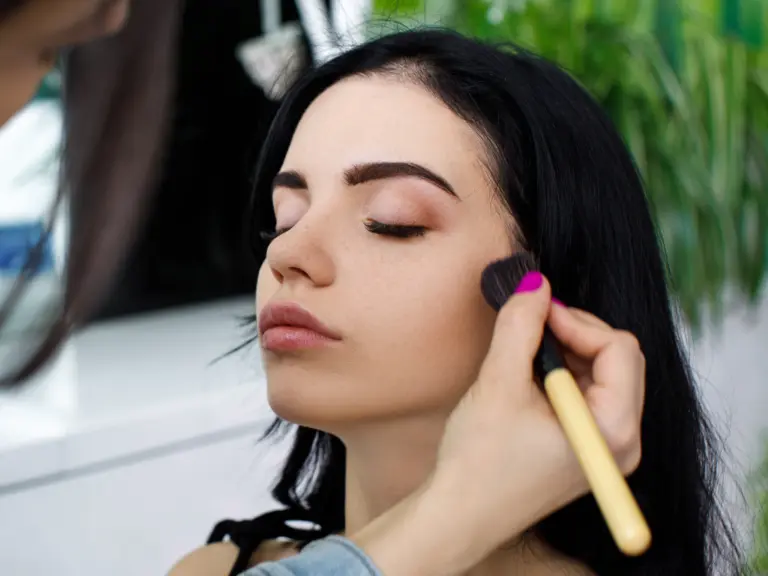 Irina Rico, con una clienta en su domicilio para maquillaje Aplicando maquillaje facial profesional para acabado natural y uniforme.