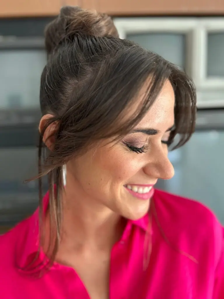 Irina Rico, con una clienta en su domicilio para peluquería Luciendo recogido alto desenfadado con flequillo suelto y acabado elegante.