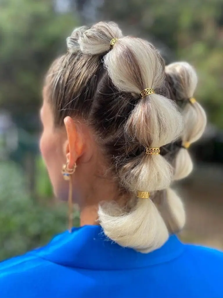 Irina Rico, con una clienta en su domicilio para peluquería Realizando peinado burbuja recogido con coleta alta y secciones voluminosas para evento especial.